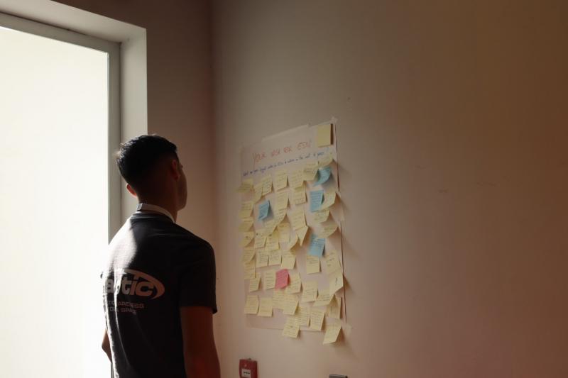 A volunteer looking at a wall filled with post-its