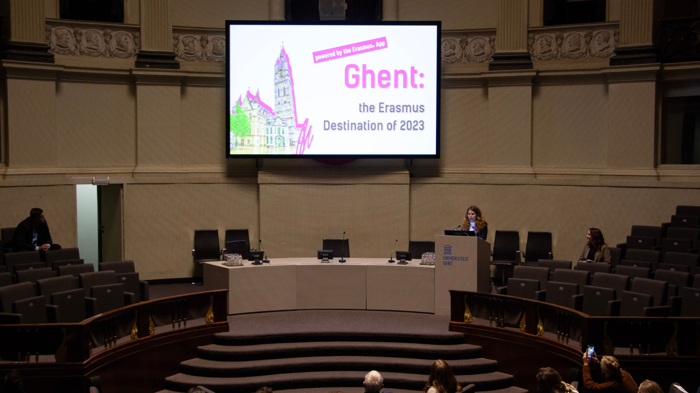 A person having a presentation about Erasmus Destination of the Year 2023 (Ghent, Belgium) in a round room.