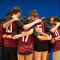 A picture of a volleyball team hugging.