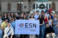 A group of young people posing for a picture with an ESN Sarajevo flag