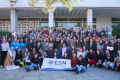 A big group of people posing for a picture with a flag of ESN Greece.