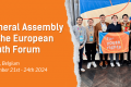 Image with orange background. On the left side is the text: "General Assembly of the European Youth Forum", followed by the location and the date of the event. On the right side there is an image with 7 young men who hold a flag that has the text "for youth rights" on it.