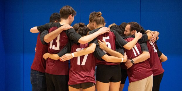 A picture of a volleyball team hugging.